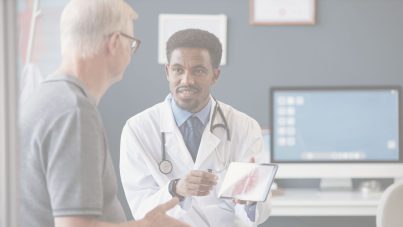 A doctor holds a tablet with a picture of lungs and speaks with a patient in an exam room